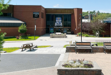Spring photo of the main doors and plants around Nipissing University on a sunny day